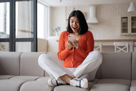 woman looks her phone excitedly