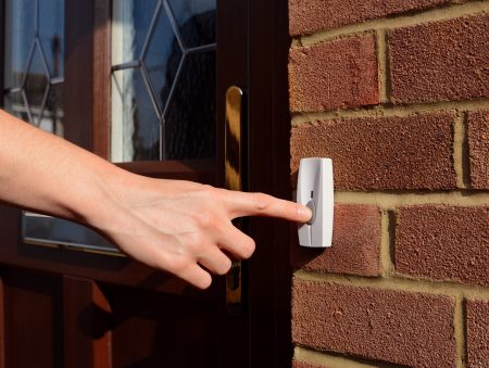 hand ringing doorbell