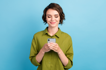 woman green shirt short hair holds phone