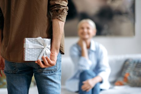 man holds gift behind back