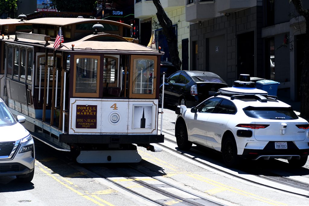 A Waymo passes a cable car in San Franciscos Union Square. GeekWire photo JiaYing Grygiel