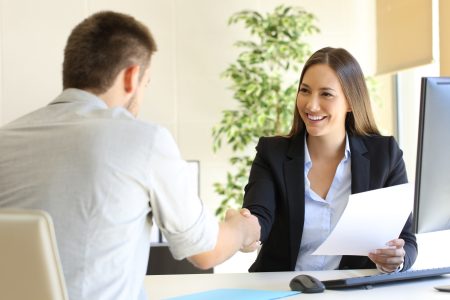 man woman shake hands during interview