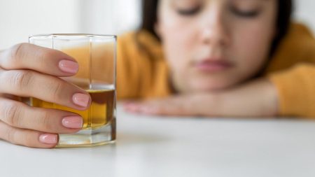 person holding whiskey glass alone