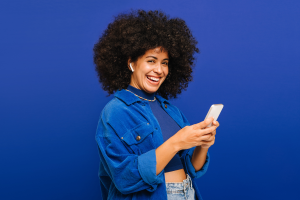 woman holds cell phone against blue background