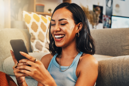 woman smiling phone sitting against couch