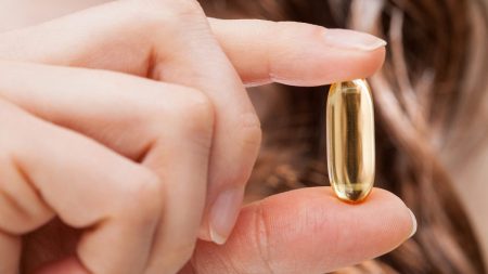 close up of person holding vitamin capsule