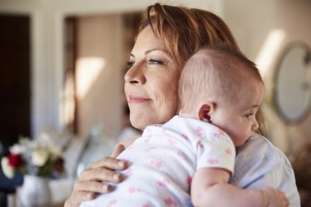 middle aged woman holds baby