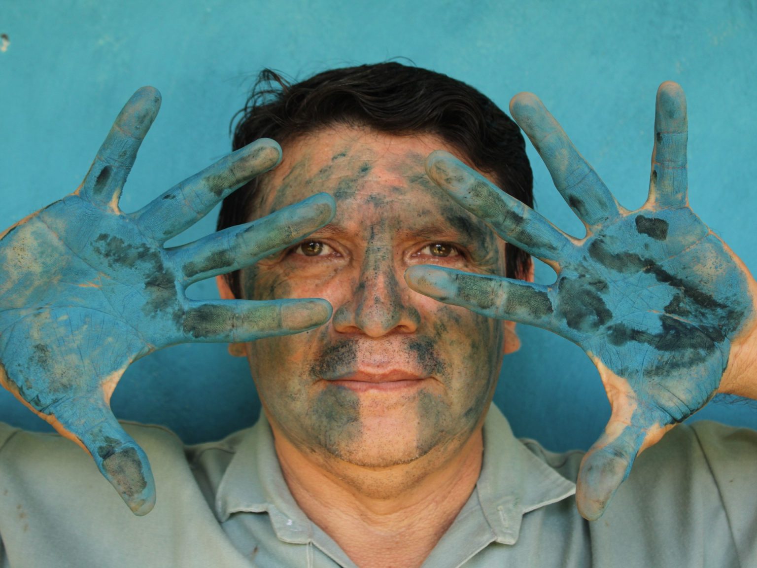 Luis May Ku 49 poses with his hands painted in Maya Blue outside his home in Dzan Yucatan Mexico on