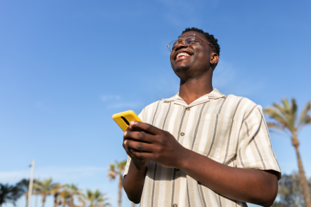 man blue sky striped shirt mobile phone