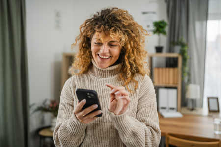 woman curly hair turtleneck sweater phone home