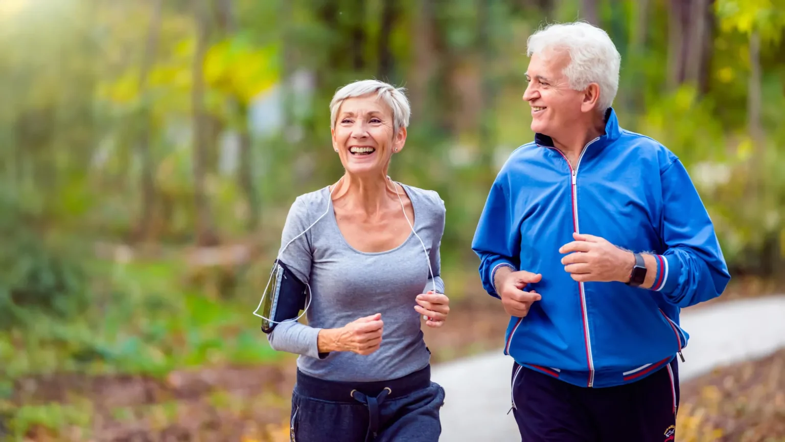 happy senior couple jogging in park.webp