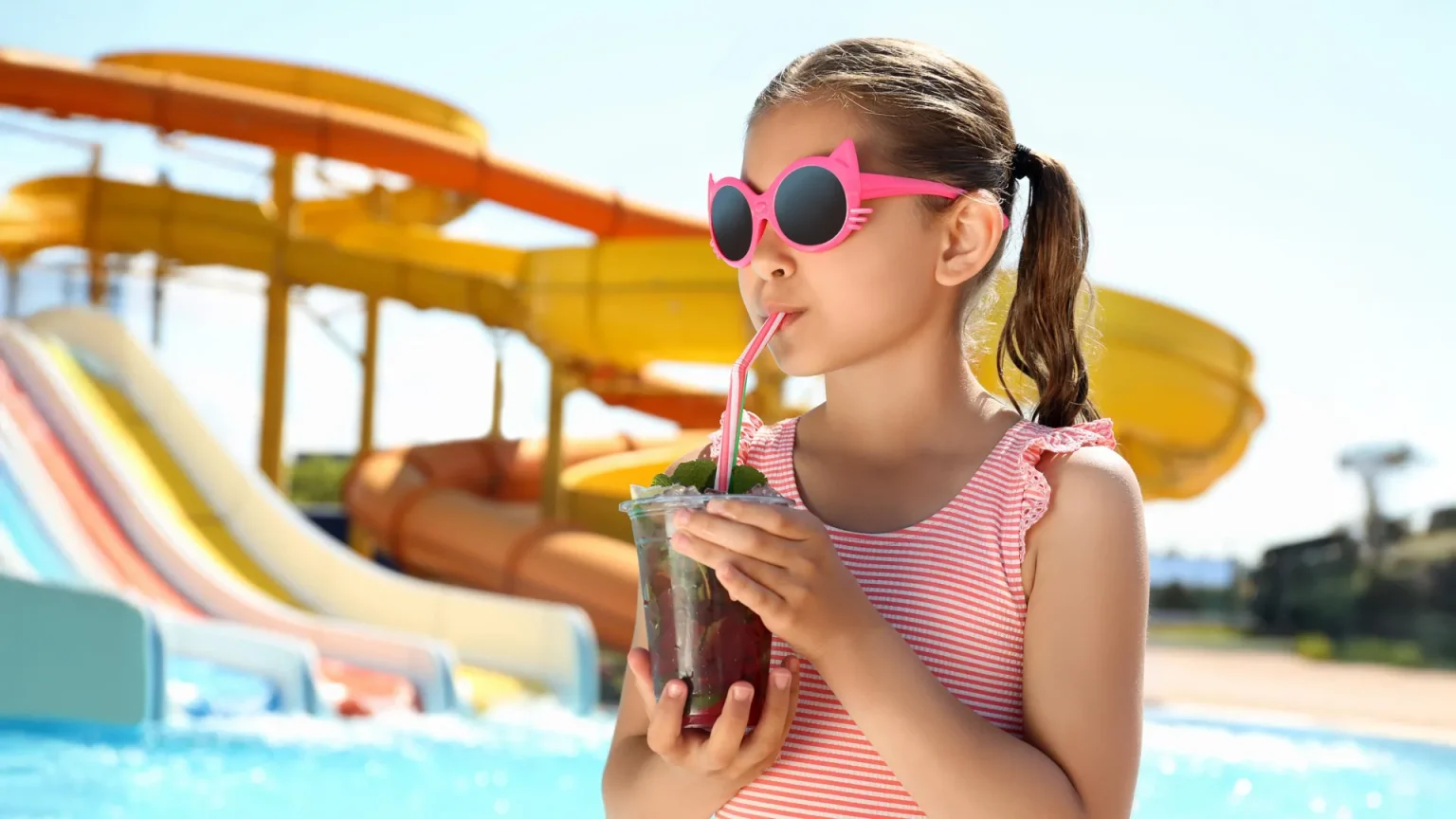 little girl cold drink water park.webp