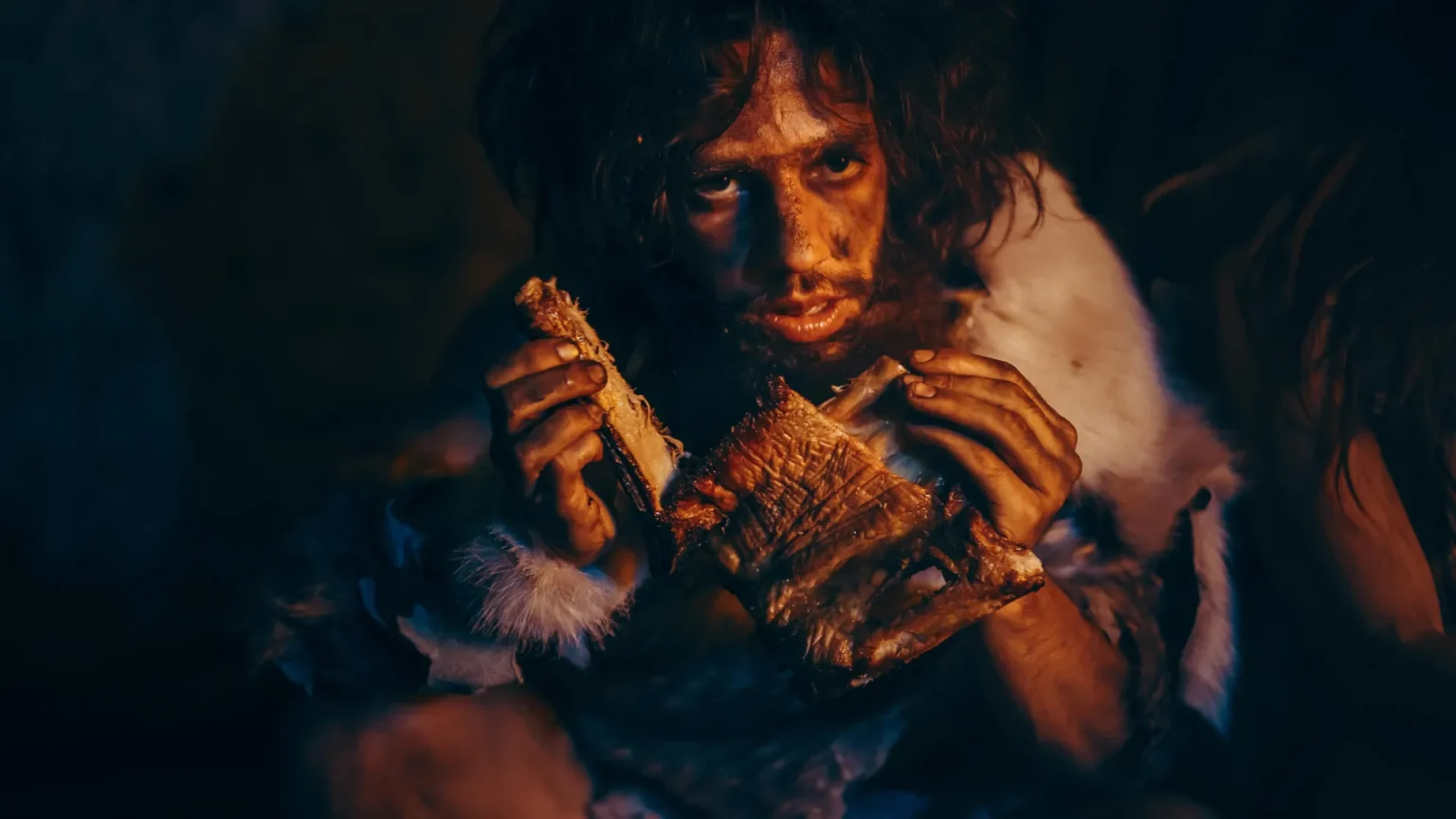 neanderthal man eating meat.webp