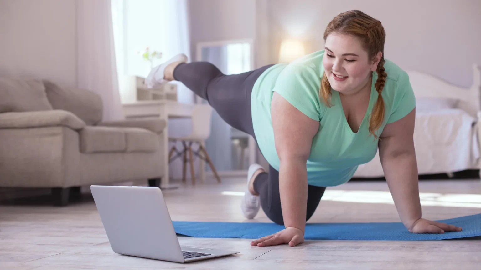 obese woman exercising with laptop.webp