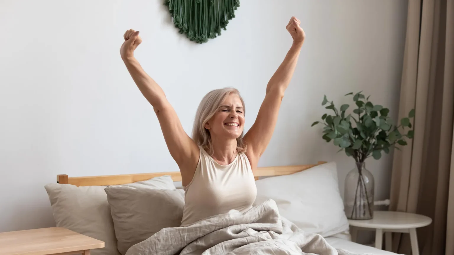 older woman waking up in bed happy.webp