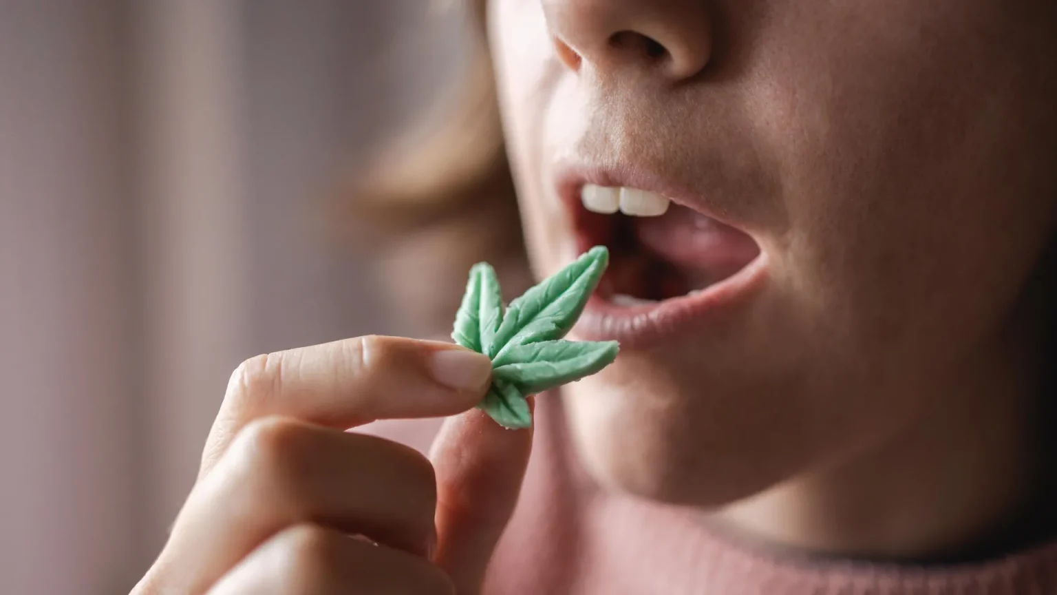 woman eating cannabis edible leaf.webp