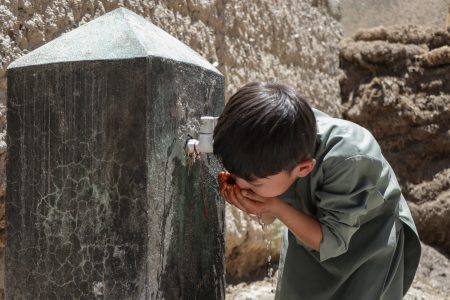 afghan hazara boy drinks water