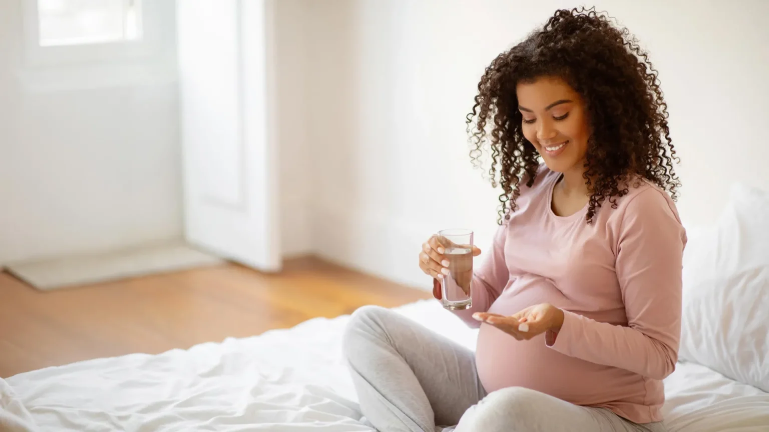 smiling pregnant woman vitamins.webp