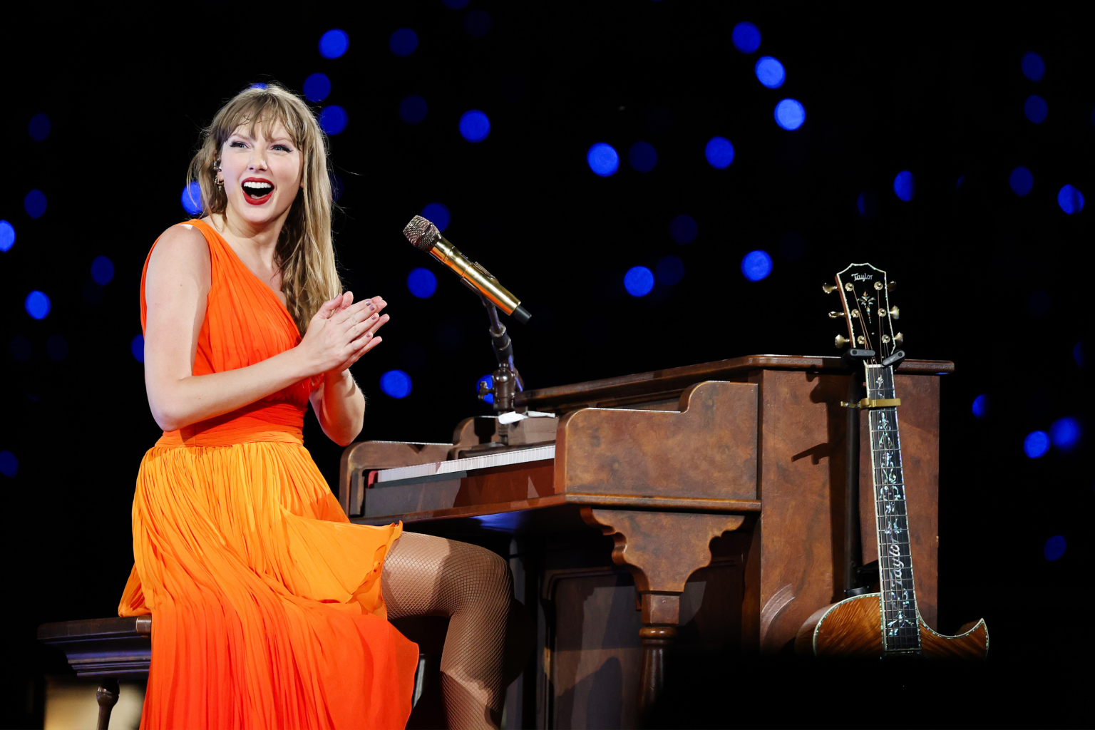 taylor swift performs orange dress piano guitar