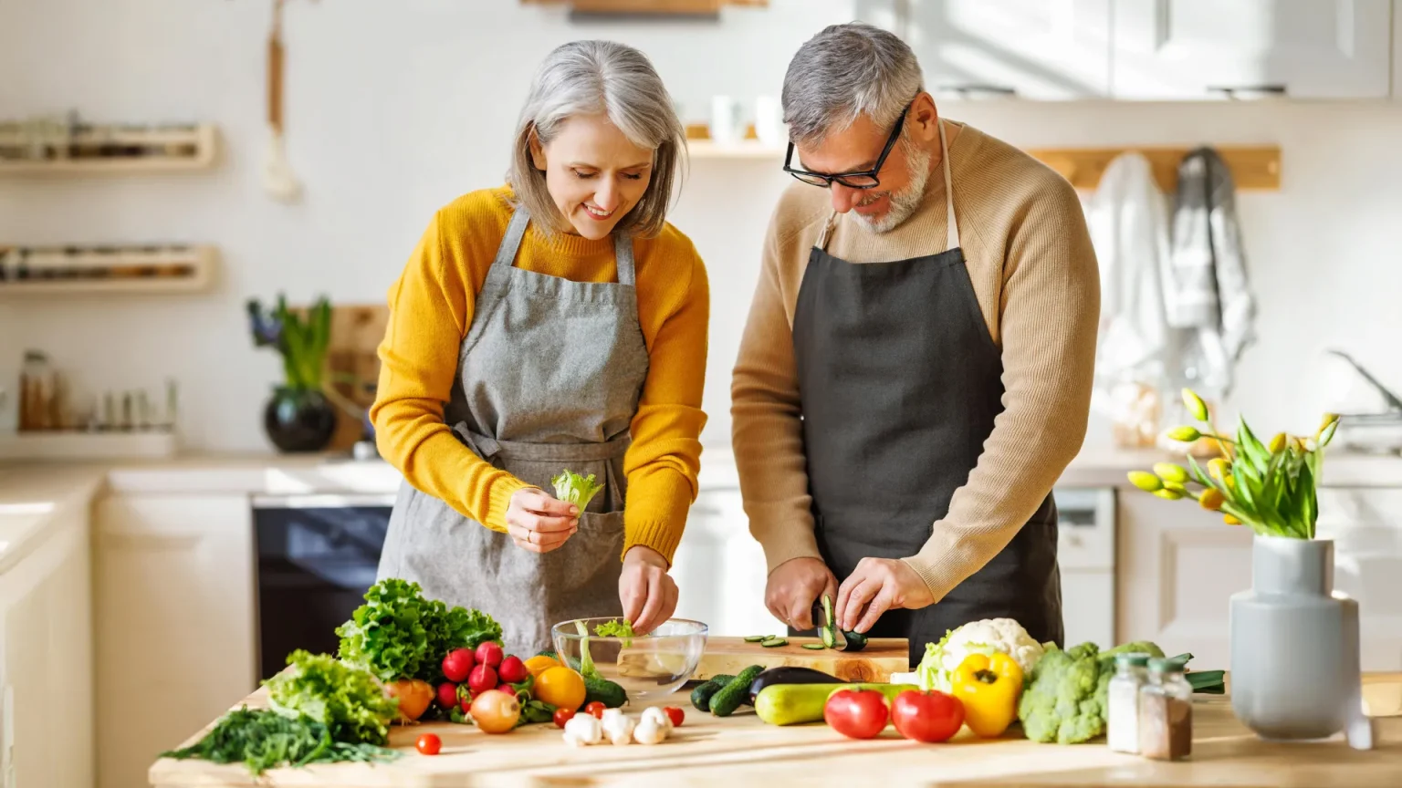 senior couple in kitchen preparing healthy salad.webp