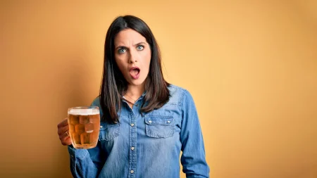 shocked woman holding beer.webp