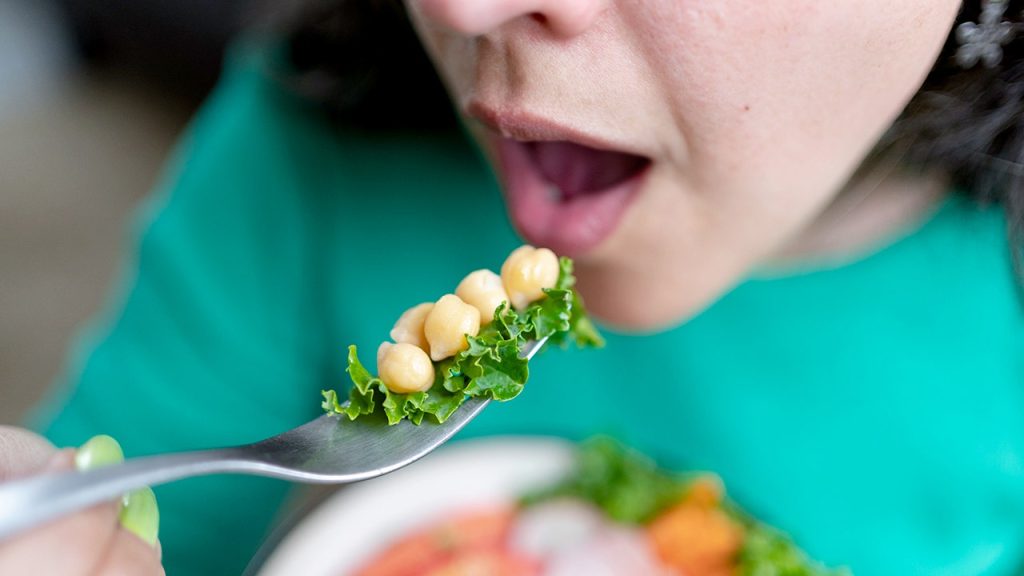 woman eating chickpeas with fork