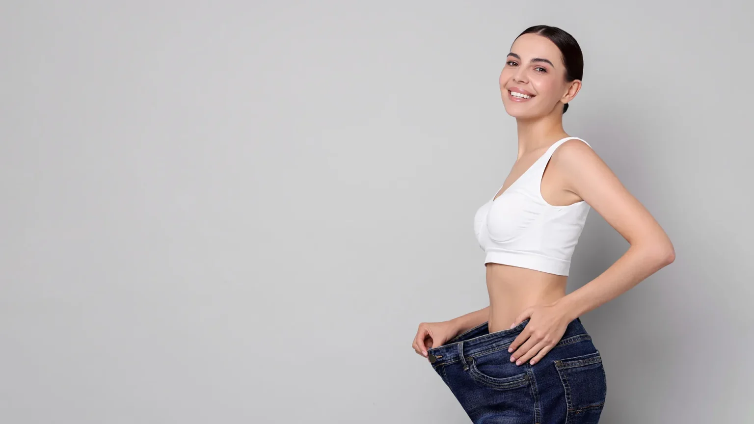 woman weight loss happy loose jeans.webp